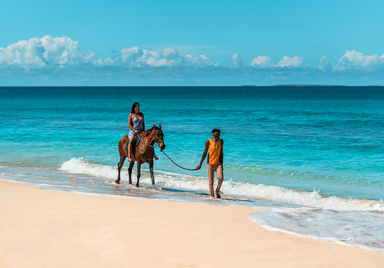 Lady riding a horse on the beach